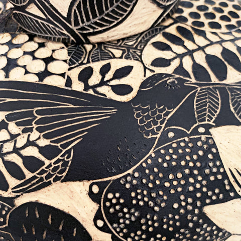 Detail of hummingbird from black and white lidded vessel with handle in black terra sigilata and sgraffito with crows and hummingbird by Carolyn Blazeck at Cottage Curator - Sperryville VA Art Gallery